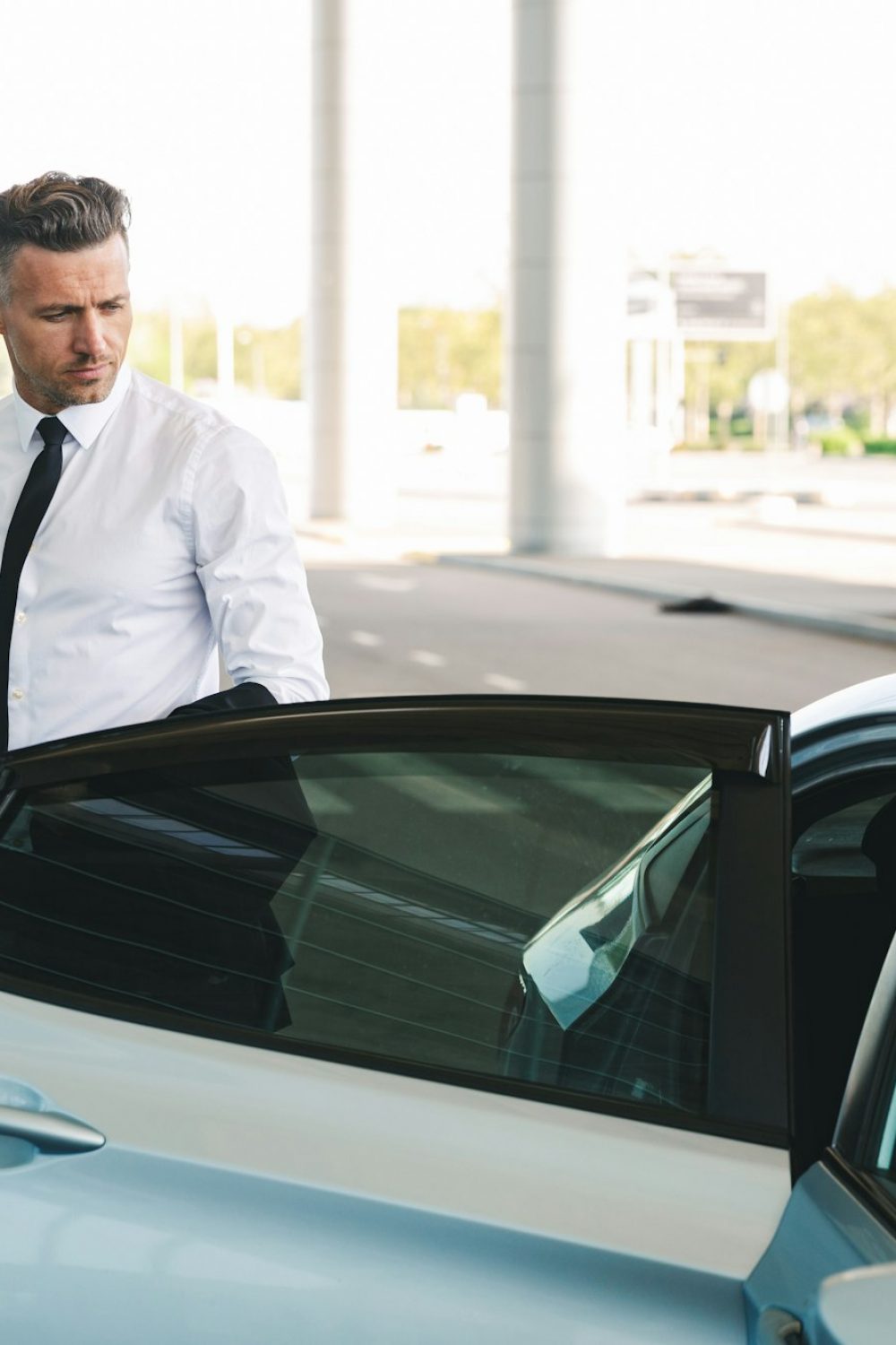 Handsome mature businessman getting in taxi